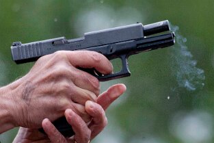 Impressionen MKP Impressionen MKP Monte Kali Pokalschießen Bild: Hände eines alten Mann halten leergeschossene Glock mit nach hinten gefahrenen Schlitten. Mündungsqualm zieht...