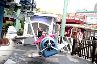 Vergnügungspark Liseberg in Göteborg Vergnügungspark Liseberg in Göteborg Bild: mit ausgestreckten Armen fliegt das kleine Mädchen im Flugzeug in diesem Fahrgeschäft